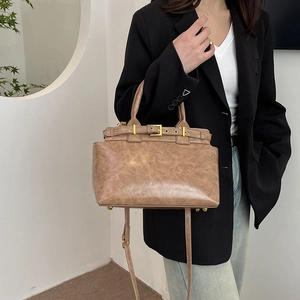 Vintage brown leather tote bag with gold buckle hardware and adjustable shoulder strap