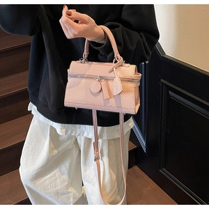 Detailed view of a pink textured lunchbox bag featuring silver zipper and crossbody strap