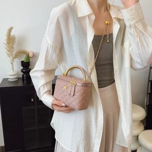 Quilted rose pink mini box bag with gold floral logo and chain strap on female model