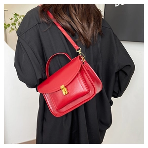Détail du sac messager vintage rouge en cuir PU poli avec une boucle carrée dorée