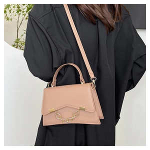 Khaki chain small square bag worn by a model in a black casual shirt with white background