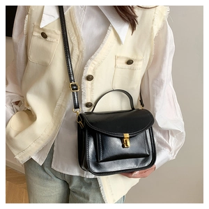 Détail d'un sac à bandoulière vintage en cuir huilé noir avec fermoir doré chic
