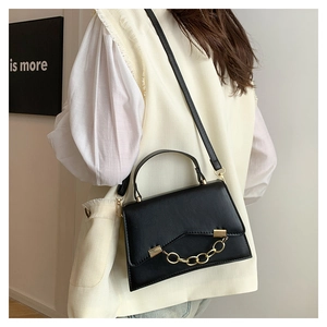 Detail of black PU leather crossbody bag featuring gold chain link and square metal buckle
