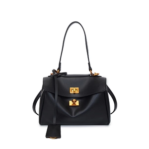 Detail of black leather shoulder bag with gold metal twist locks and vintage texture