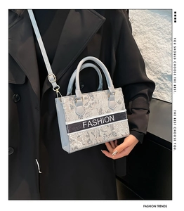 Light blue embroidered tote bag with FASHION webbing and detachable strap shown on model