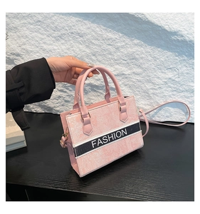 Detail of pink embroidered handbag with fashion strap and floral textured pattern