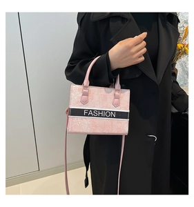 Detail view of pink embroidered tote bag with Fashion text and crossbody strap