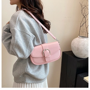 Detail of pink faux leather underarm bag with silver buckle worn by a model