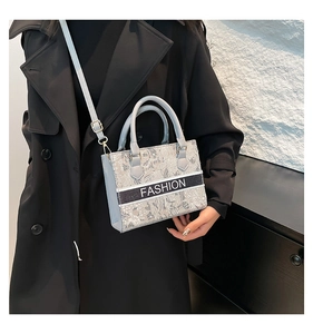 Close-up of a large capacity tote bag with 'FASHION' lettering and adjustable strap