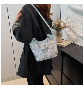 Detailed embroidery on light blue crossbody tote with delicate floral lace texture