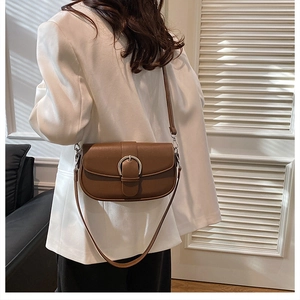 Close-up of brown vintage saddle bag with silver metal horseshoe buckle detail
