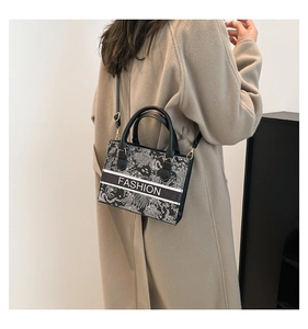 Fashion embroidered tote bag with cross-body strap shown on model's shoulder
