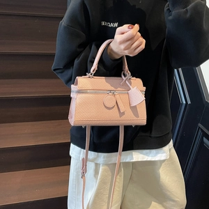 Pink structured lunch box bag with woven texture and detachable crossbody strap