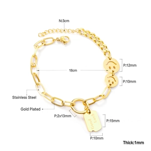 Close-up of gold plated stainless steel bracelet with engraved Good Luck charm and smiley pendant