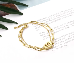 Detail of 18K gold stainless steel double chain bracelet with dual interlocking ring charm