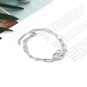 Close-up of a silver double-layered chain bracelet with interlocking rings and lobster clasp