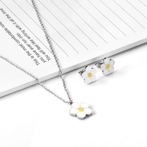 Gros plan détaillé du collier et des boucles d'oreilles marguerite sur un carnet blanc