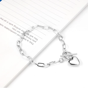 Macro shot of silver heart charm and T-bar toggle clasp on stainless steel chain bracelet