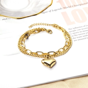 Detail of 18K gold-plated double-layer heart lock and paperclip chain bracelet