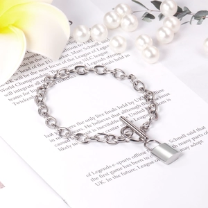 Detailed macro of a silver heart lock pendant on an OT buckle chain bracelet