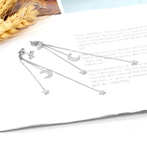 Vue détaillée des boucles d'oreilles à pompons longs avec breloques étoile et lune