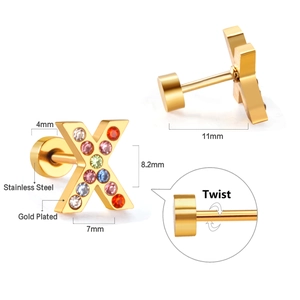 Macro detail of X-shaped gold plated stainless steel earring with colorful crystals