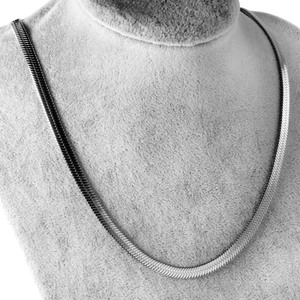 Macro detail of silver herringbone chain necklace on a professional grey jewelry display