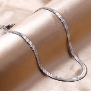 Flat silver stainless steel snake chain necklace on silk fabric with lobster clasp