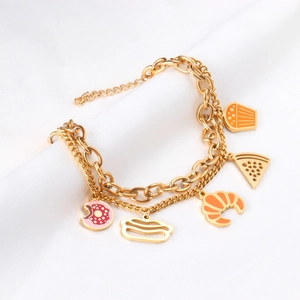 Detail of double-layer gold chain bracelet with colorful food pendants like donuts and pizza