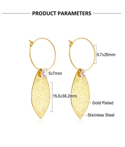 Detalle de pendientes de hoja en acero dorado con circonita de gota y textura floral