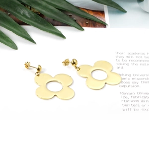 Detailed view of gold floral hollow earrings with a polished mirror finish surface