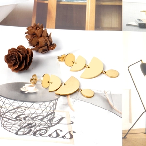 Detailed view of golden multi-layer geometric earrings on a magazine background