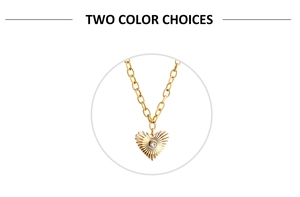 Detail of gold heart pendant with radial texture and crystal inlay on a link chain