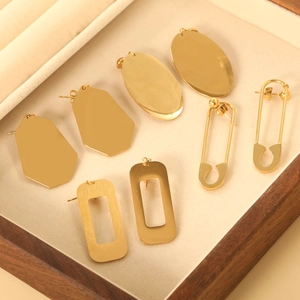 Selection of geometric gold plated stainless steel earrings in a wooden jewelry box