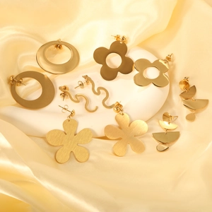Minimalist gold geometric earrings set with hoop, flower and oval designs on white marble