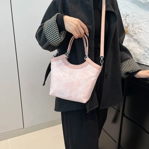 Sac à main rose de style chinois avec broderie florale porté par un mannequin