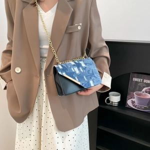 Chic color-block shoulder bag in denim blue and black with gold chain strap for women