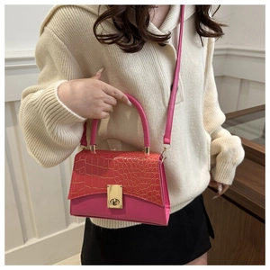 Detailed view of pink crocodile pattern texture and golden round rotating lock on handbag
