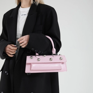 Chic pink baguette handbag with silver studs and a sleek finish for modern women