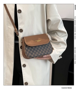 Close-up of brown vintage saddle bag featuring classic pattern and adjustable strap