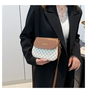 Close-up of vintage brown leather and checkered canvas crossbody saddle bag on a model