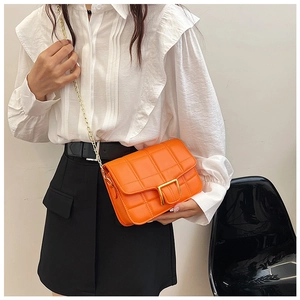 Detail of bright orange quilted PU leather bag with gold U-shaped magnetic buckle