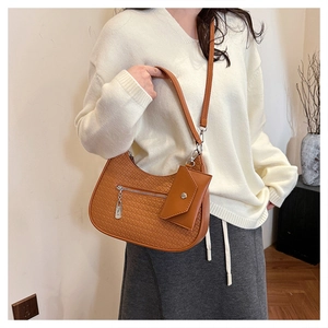 Detail einer braunen geflochtenen Halbmondtasche mit passender kleiner Tasche am Model
