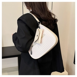 Detail der gewebten cremefarbenen Tasche mit abnehmbarem Etui auf schwarzem Blazer