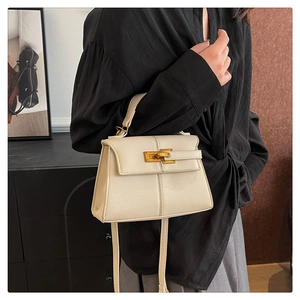 Dettaglio della borsa beige in pelle martellata con chiusura a scatto dorata