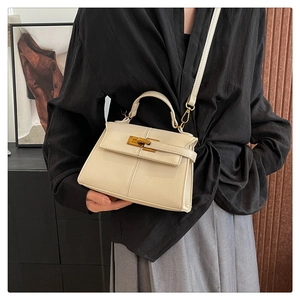 Dettaglio della borsa a trapezio in pelle crema con chiusura a scatto dorata
