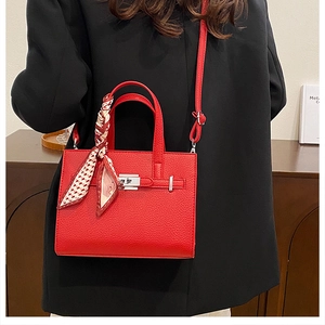 Détail du sac cabas rouge en cuir litchi avec foulard en soie et fermoir métallique