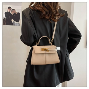 Dettaglio borsa a mano beige in pelle martellata con chiusura a girello dorata e manico