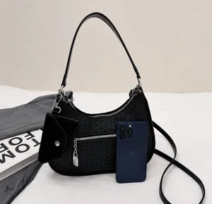 Detail showing woven texture of black hobo bag with mini card holder and silver lock