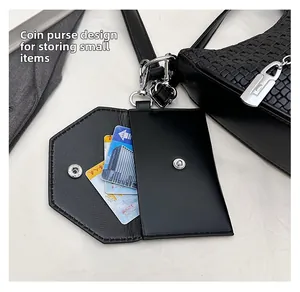 Detail of detachable woven coin purse with silver snap closure on black shoulder bag
